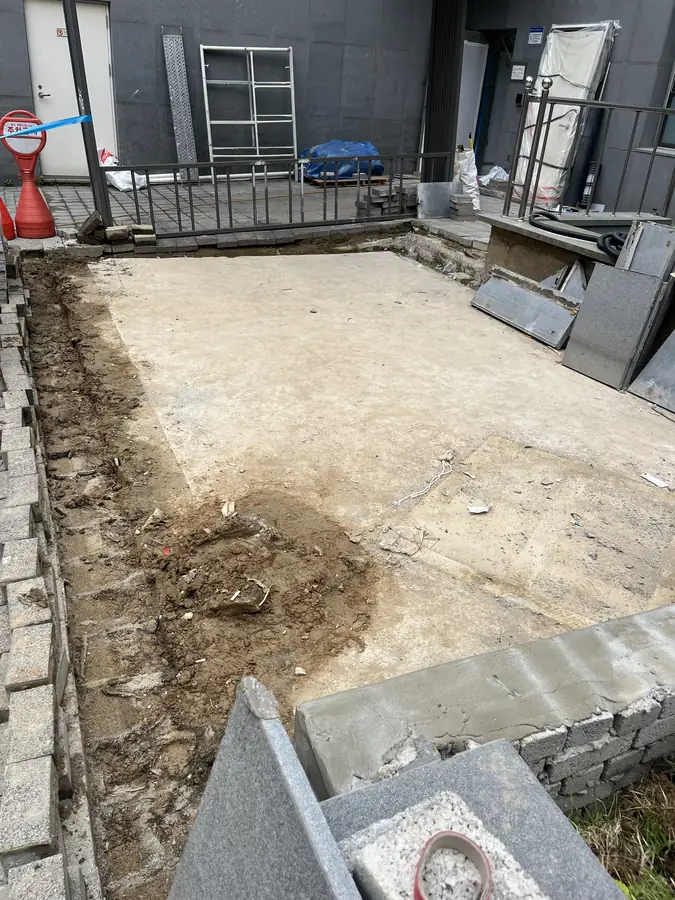 건물 옆 공터 바닥이 침하되어 흙바닥과 깨진 경계석이 드러난 시공 전 현장